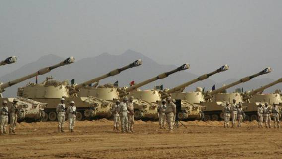 Saudi soldiers stand at attention in fro