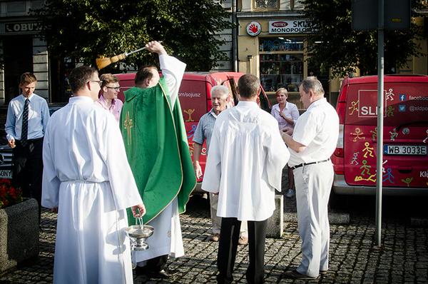 Kampanijne wozy SLD poświęcone przez księdza
